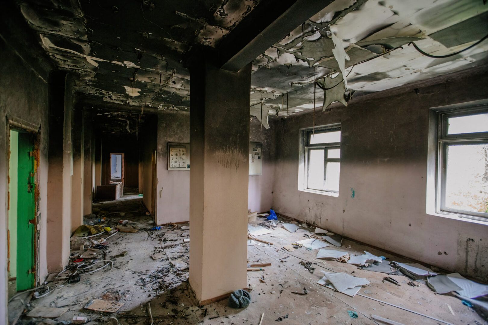 Abandoned, dilapidated room with debris scattered.