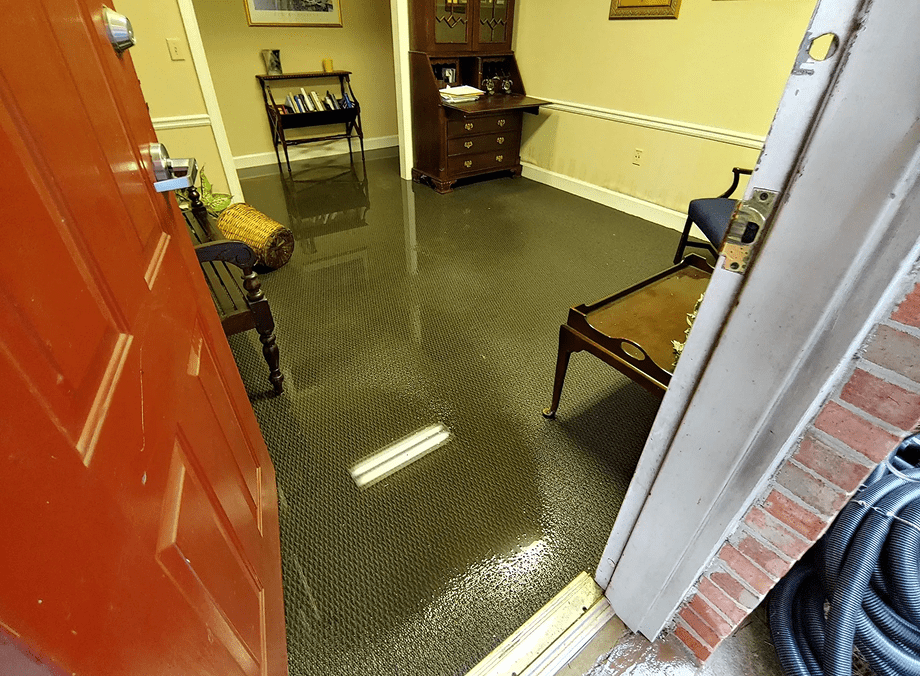 Flooded room with furniture and open door.